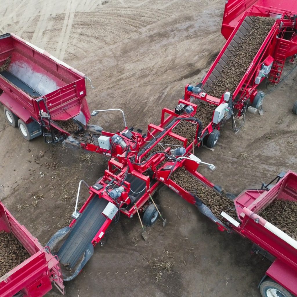 The 1695 – Custom Collector in the middle of 4 transportation trucks.