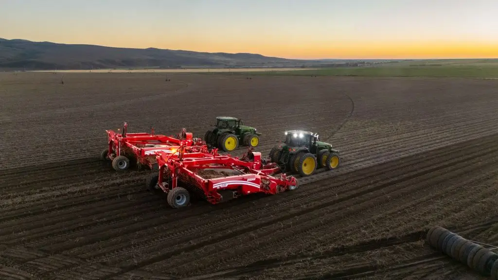 2 Spudnik Potato Windrowers Attached to 2 John Deer Tractors in a potato Field, digging potatoes